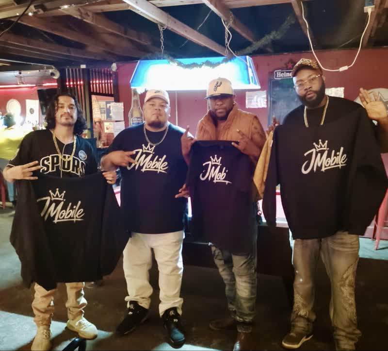 Customers holding up JMobile shirts on a night out